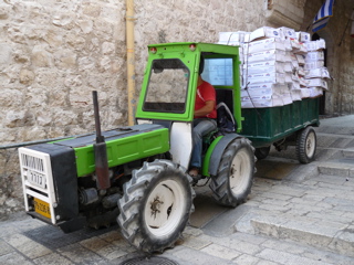 Tractor pulling goods from Australia and Brazil through the narrow streets of Old Jerusalem (rw)