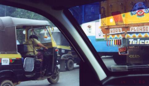 Street scene with truck marked "Horn Please"